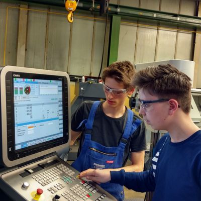 Daniel H�bner, Industriemechaniker im 3. Lehrjahr, zeigt den interessierten Achtkl�sslern einen Roboter, mit dem man Metallst�cke sehr variabel, mit unterschiedlichen Werkzeugen gleichzeitig bearbeiten kann.