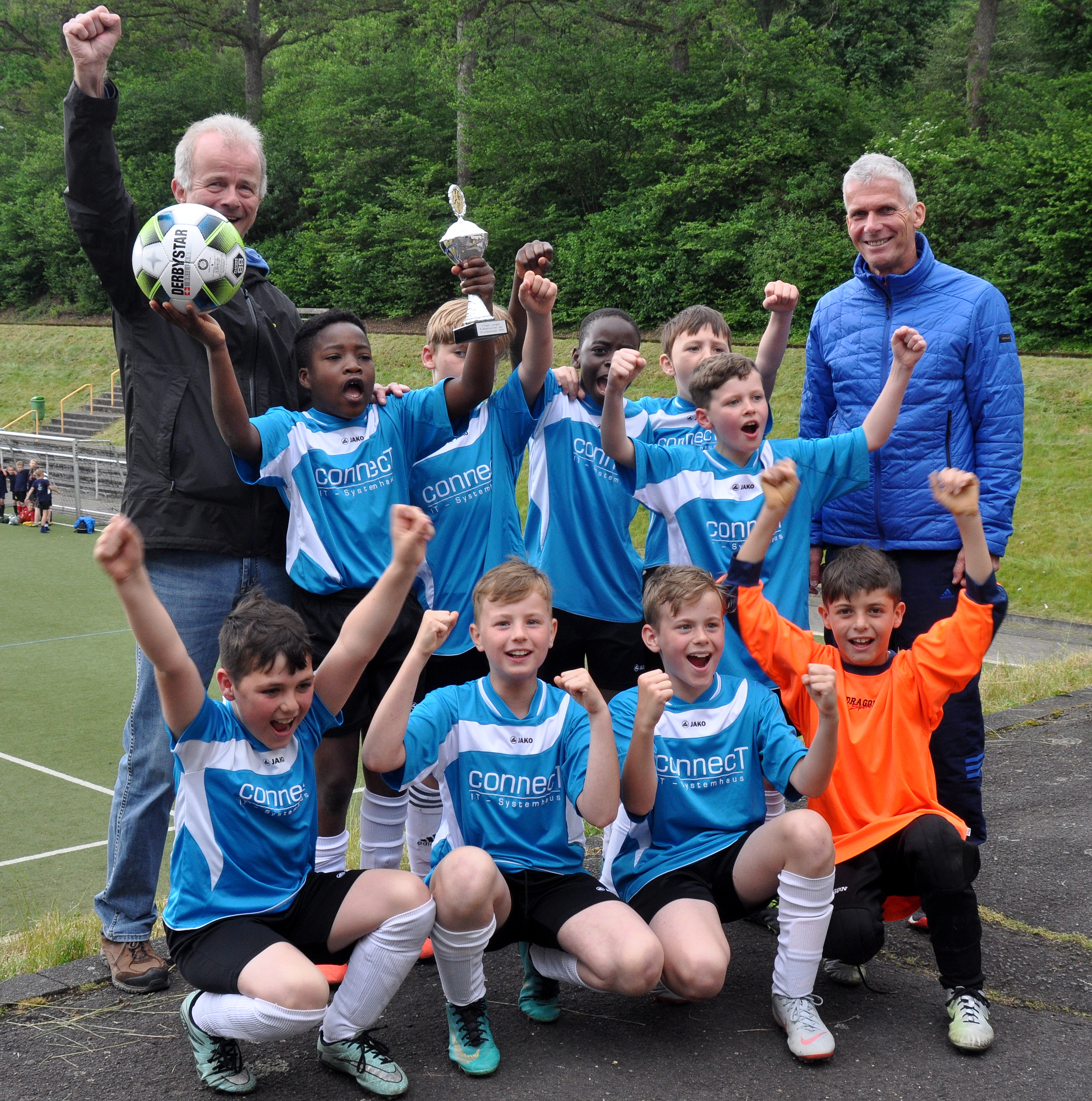 Freuten sich &uuml;ber den Pokal: Das Team der Grundschule Dreisbachtal (Siegerteam Jungen) mit ihrem Sportlehrer R&uuml;diger Harth (links) und Schulsportberater Bernd Kr&auml;mer (rechts).
