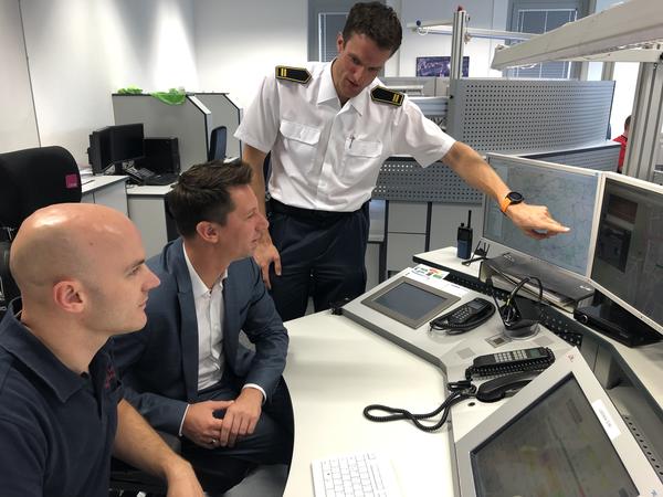 Landrat Andreas M�ller (Mitte) l�sst sich von Amtsleiter Thomas Tremmel (r.) die zwei neuen Systeme im Dispositionsraum der Kreisleitstelle erkl�ren.