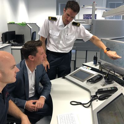 Landrat Andreas M�ller (Mitte) l�sst sich von Amtsleiter Thomas Tremmel (r.) die zwei neuen Systeme im Dispositionsraum der Kreisleitstelle erkl�ren.