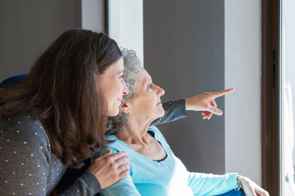 Adult daughter visiting elderly mother