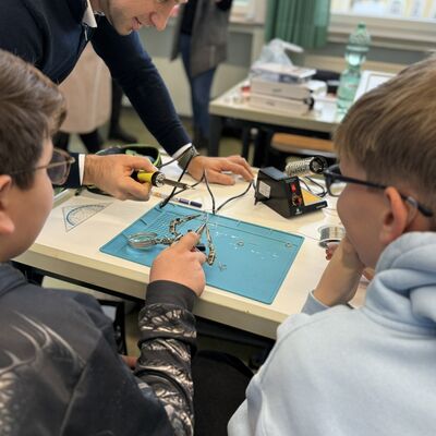 Teamwork: Prof. Denis Anders (oben), Markus (l.) und Leonhard (r.) bei der Arbeit mit dem L�tkolben.