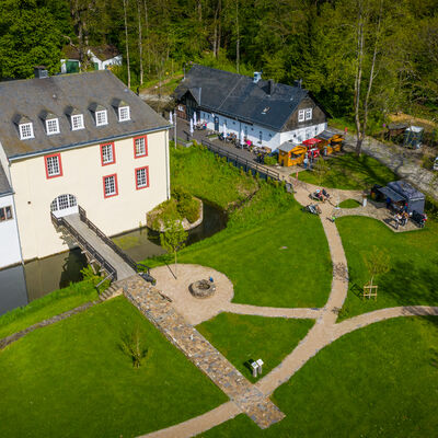 Die Wasserburg in Hainchen von oben. Sie ist die einzige H�henwasserburg in Suedwestfalen. Urkundlich erstmals erw�hnt wurde die Burg im Jahr 1290. Seit den 1970er-Jahren ist der Siegerl�nder Burgenverein Tr�ger der Wasserburg. Heute ist sie ein beliebtes Ausflugsziel. In  der Remise an der Wasserburg befindet sich ein Restaurant mit Eventlocation.