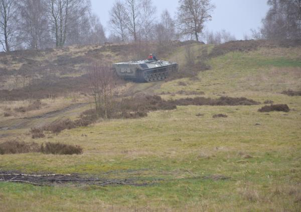 Eine gro�e Fl�che Wiese mit einigen Mulden. Im Hintergrund der Panzer im Einsatz.