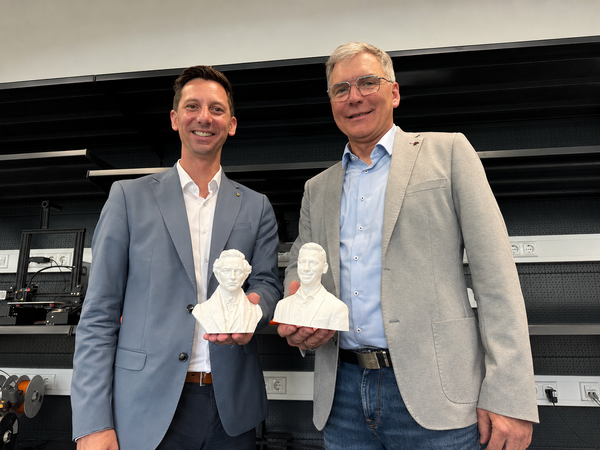 200 Jahre Berufskolleg Technik des Kreises Siegen-Wittgenstein: Schulleiter Ralf Bruch (r.) hat eine B�ste von Landrat Andreas M�ller in der Hand, Landrat M�ller wiederum von seinem Vorg�nger Wilhelm Friedrich von Schenk. Schenk war der erste Landrat des Kreises Siegen-Wittgenstein und hat vor 200 Jahren den Vorl�ufer des BK Technik und damit die berufliche Bildung insgesamt intensiv gef�rdert. Die B�sten wurden vom BK mit 3D-Druckern gefertigt.